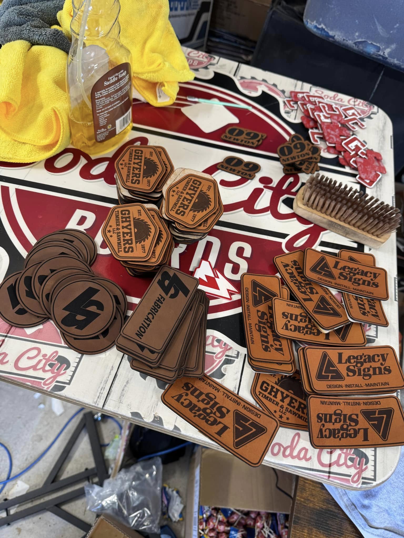 A leather piece being gently wiped down with a soft cloth to remove any residual dust or debris after laser engraving